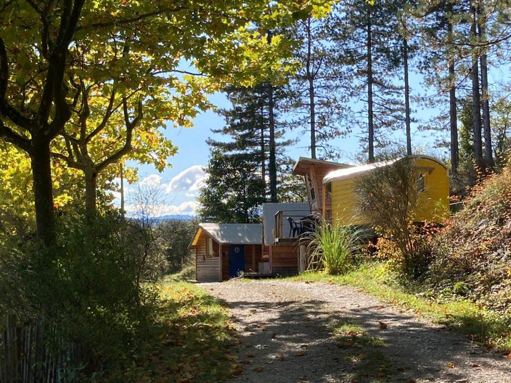 Vue sur 3 cabanes du camping en haut d'un chemin